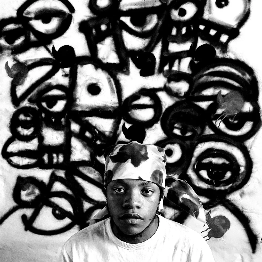 Potrait of Shady, a South African street artist, standing in front of one of his Graffiti Wall.